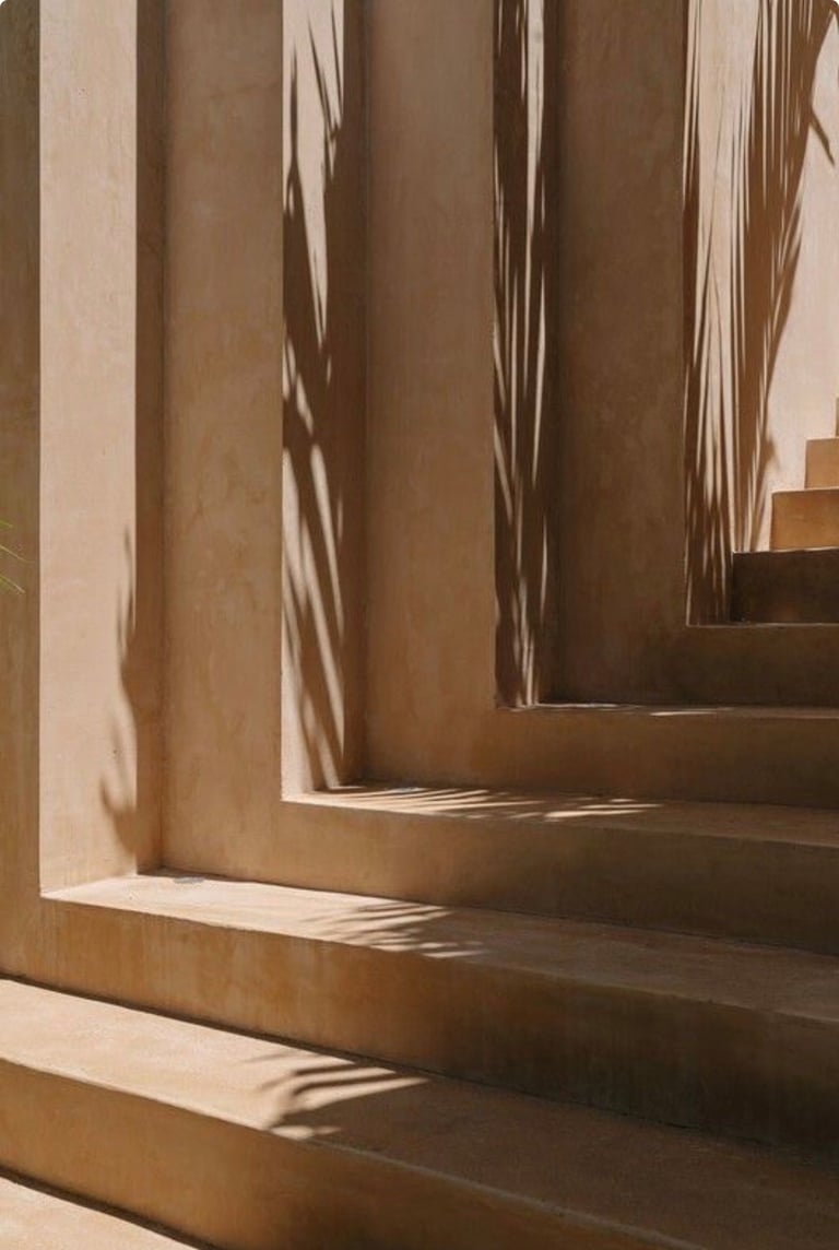 Narrow corridor with beige walls and wooden steps casting diagonal shadows from sunlight streaming through a window